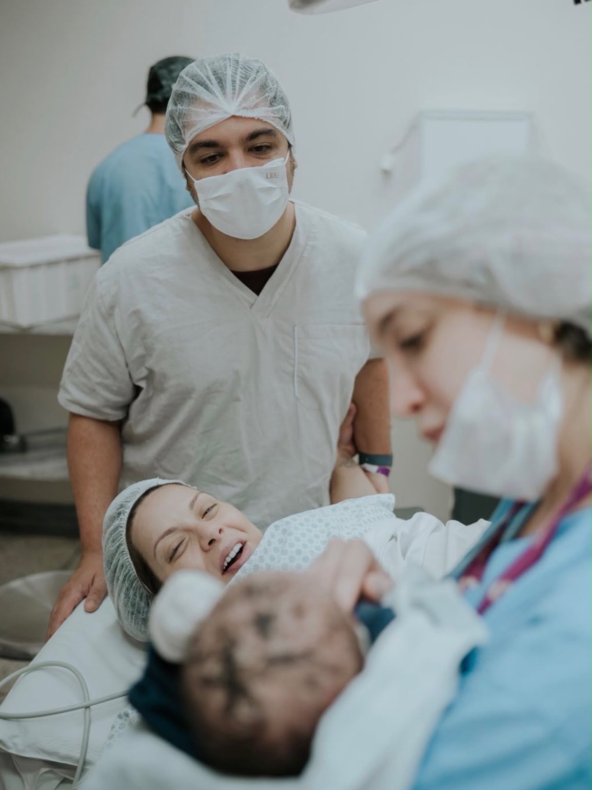 Equipe obstétrica acolhendo o bebê junto à família após o nascimento